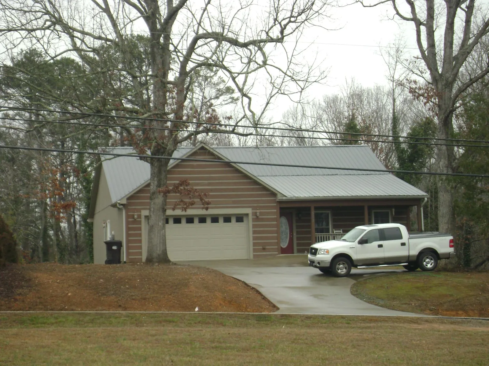 Gray metal roof on a log sided house with an attached two car garage in Riverton